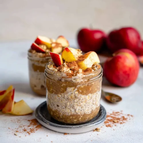 Apple Cinnamon Overnight Oats in a glass jar topped with cinnamon and fresh apple slices