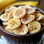 Crispy cinnamon sugar banana chips in a brown bowl