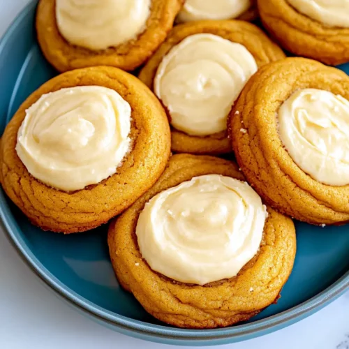 Pumpkin cheesecake cookies with creamy cheesecake filling on a blue plate, soft and chewy fall dessert perfect for Thanksgiving.