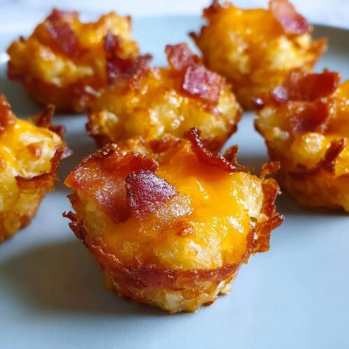 Close-up of delicious Cheesy Bacon Tater Tot Cups, golden brown and topped with crispy bacon.