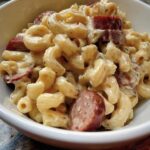 A bowl of Creamy Ranch Potato Pasta with Smoked Sausage, coated in a rich sauce and garnished with herbs.