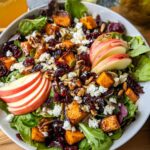 A vibrant Fall Harvest Salad with Cranberries, featuring roasted sweet potatoes, apples, feta cheese, nuts, and dried cranberries.