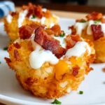 Close-up of Loaded Tater Tot Bites topped with cheese, sour cream, bacon, and chives.