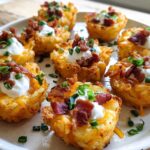 Close-up of delicious Ranch Tater Tot Appetizers topped with cheese, sour cream, bacon, and chives.