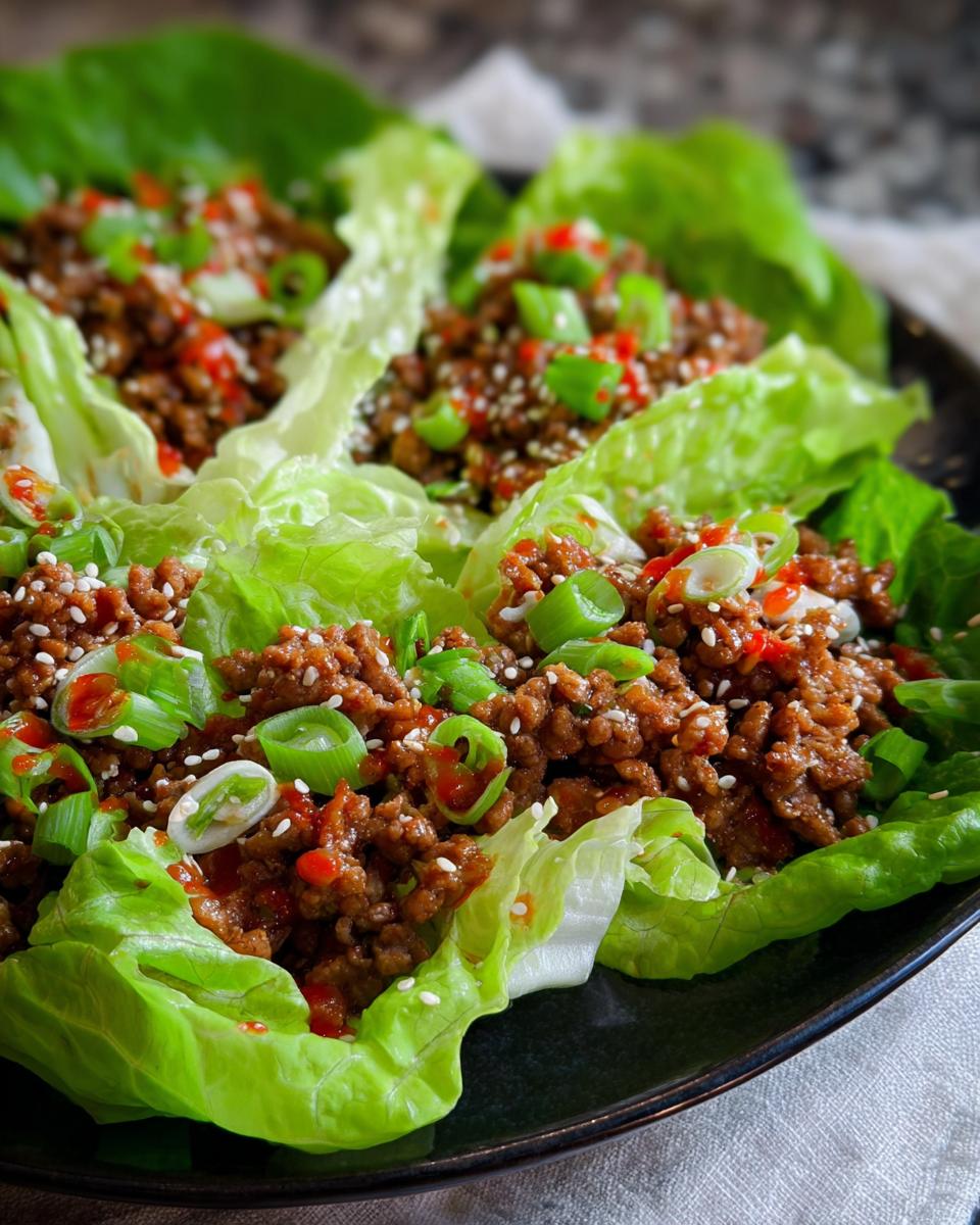 Close-up of delicious Turkey Lettuce Wraps filled with seasoned ground turkey, topped with sesame seeds and green onions.