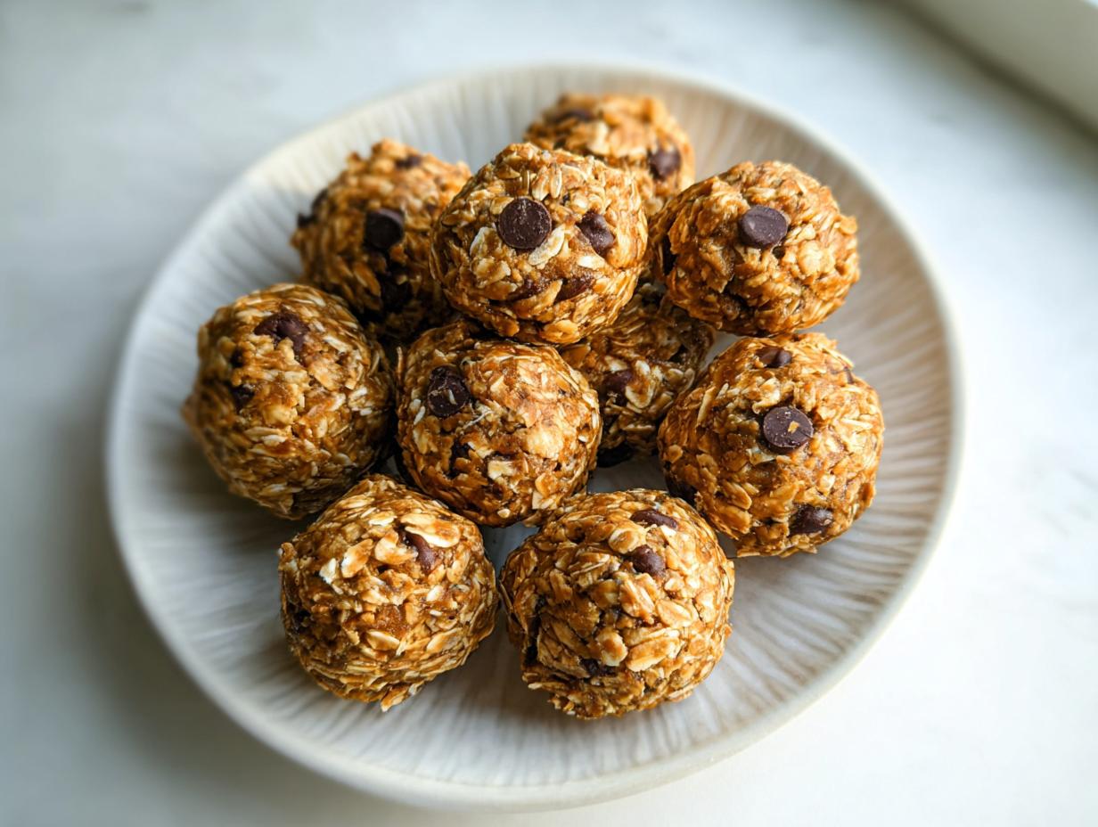 A close-up overhead shot of several chocolate chip Healthy Energy Bites stacked on a light-colored plate.