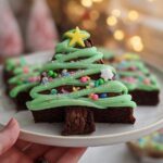 A festive Christmas Tree Brownie decorated with green icing, sprinkles, and a yellow star on top.