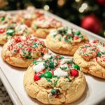 A white tray filled with festive Christmas Tree Cookies, decorated with red and green sprinkles and mini M&Ms.
