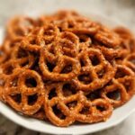 A close-up of a white bowl filled with crunchy pretzels, seasoned with spices, perfect for an easy pretzel snack recipe.