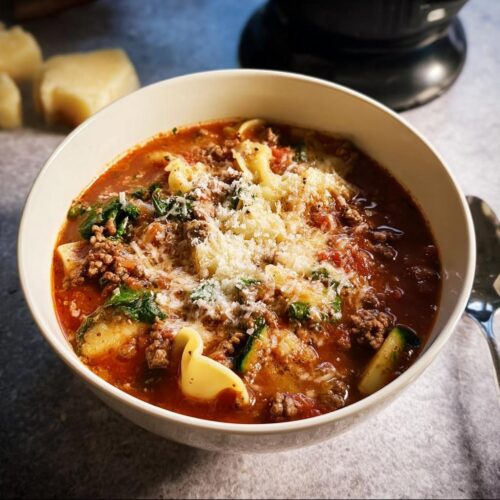 A close-up bowl of Healthy Crockpot Lasagna Soup topped generously with grated Parmesan cheese.