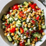 Close-up of a fresh Mediterranean Chickpea Salad featuring chickpeas, cucumber, tomatoes, feta, and herbs.