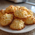 A pile of golden-brown, melt-in-your-mouth shortbread cookies on a white plate.