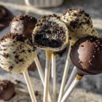 A bouquet of dark and white chocolate coated Oreo Cake Pops, one cut open to show the filling.