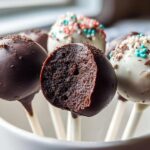 Close-up of homemade Chocolate Cake Pops, one cut in half showing the rich interior texture.