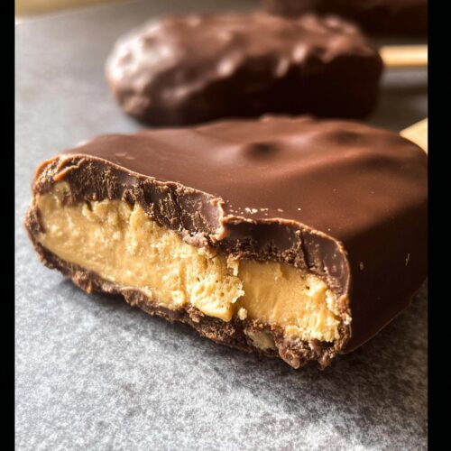 Close-up of a Chocolate Peanut Butter Freezer Bar cut in half showing the thick peanut butter filling coated in chocolate.