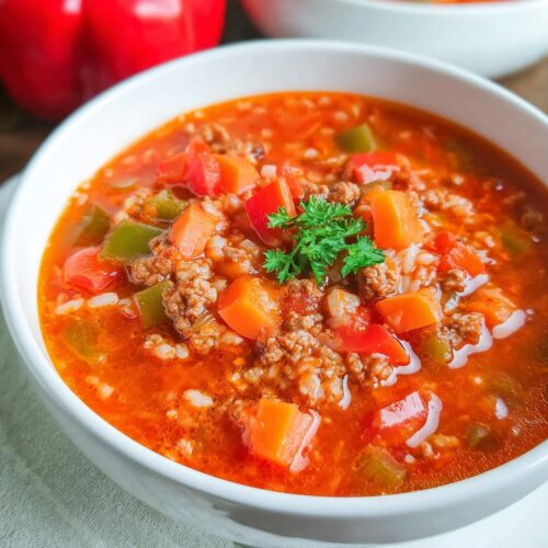 Close-up of a hearty bowl of Family Pepper Soup Recipe, rich with ground meat, rice, carrots, and peppers.