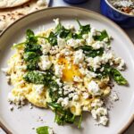Close-up of a Healthy Egg Breakfast with Feta cheese and wilted spinach on a light plate.
