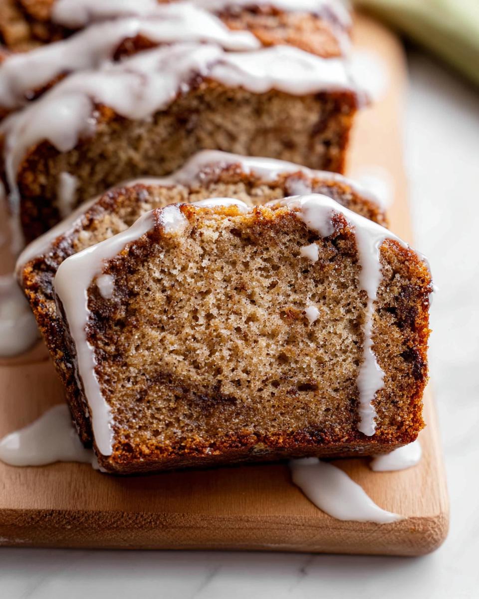 Close-up of three slices of moist Iced Cinnamon Banana Loaf drizzled with thick white icing.