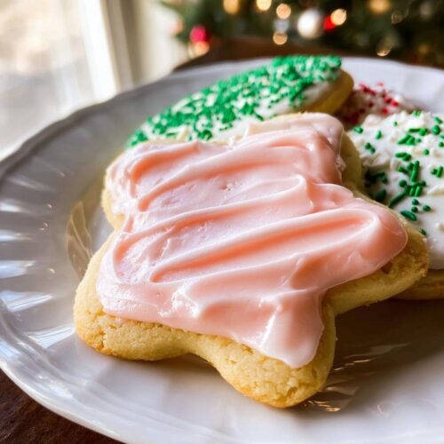 Close-up of a star-shaped sugar cookie topped with thick, pink Simple Sugar Cookie Frosting.