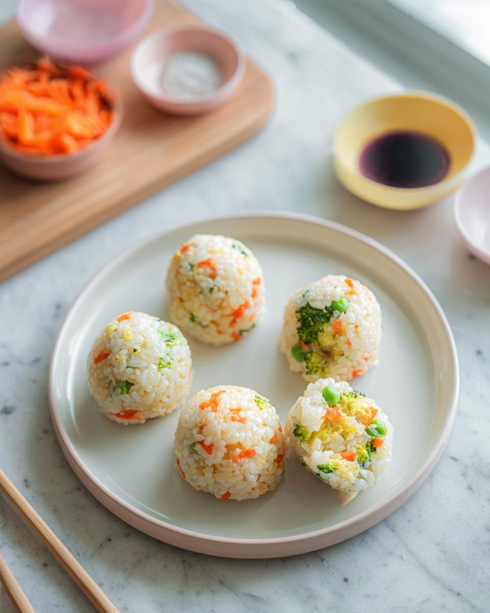 Five colorful vegetable Rice Ball Sushi Lunch portions arranged on a light plate, ready to eat.