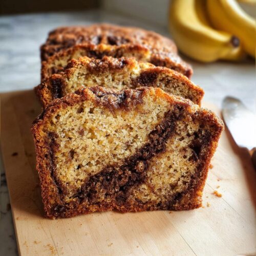 Close-up of thick slices of Banana Bread with Cinnamon Filling showing the moist crumb and dark swirl.