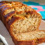Close-up of a sliced loaf of incredibly moist Sour Cream Banana Bread with a golden-brown crust.