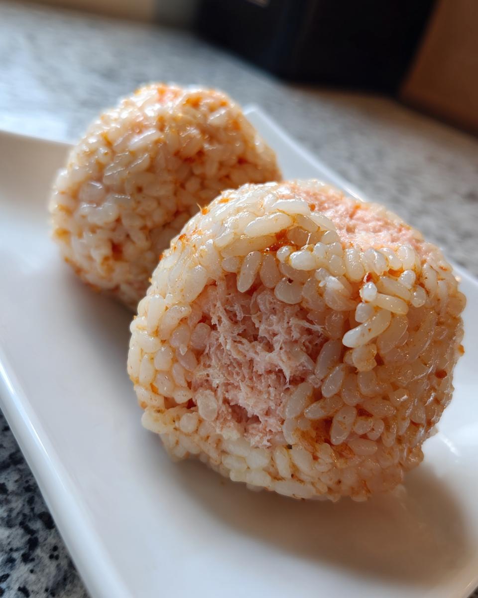 Two seasoned No-Roll Sushi Balls showing a flaky pink filling inside the rice.