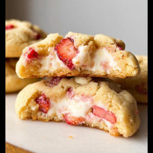 Close-up of Strawberry Cheesecake Cookies cut in half showing the creamy filling and strawberry pieces.