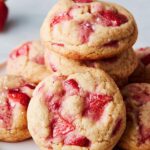 Close-up of a stack of soft, chewy Strawberry Dessert Cookies studded with bright red fruit pieces and sea salt.