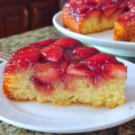 A close-up of a slice of moist Strawberry Sheet Upside Down Cake topped with glossy, caramelized strawberries.