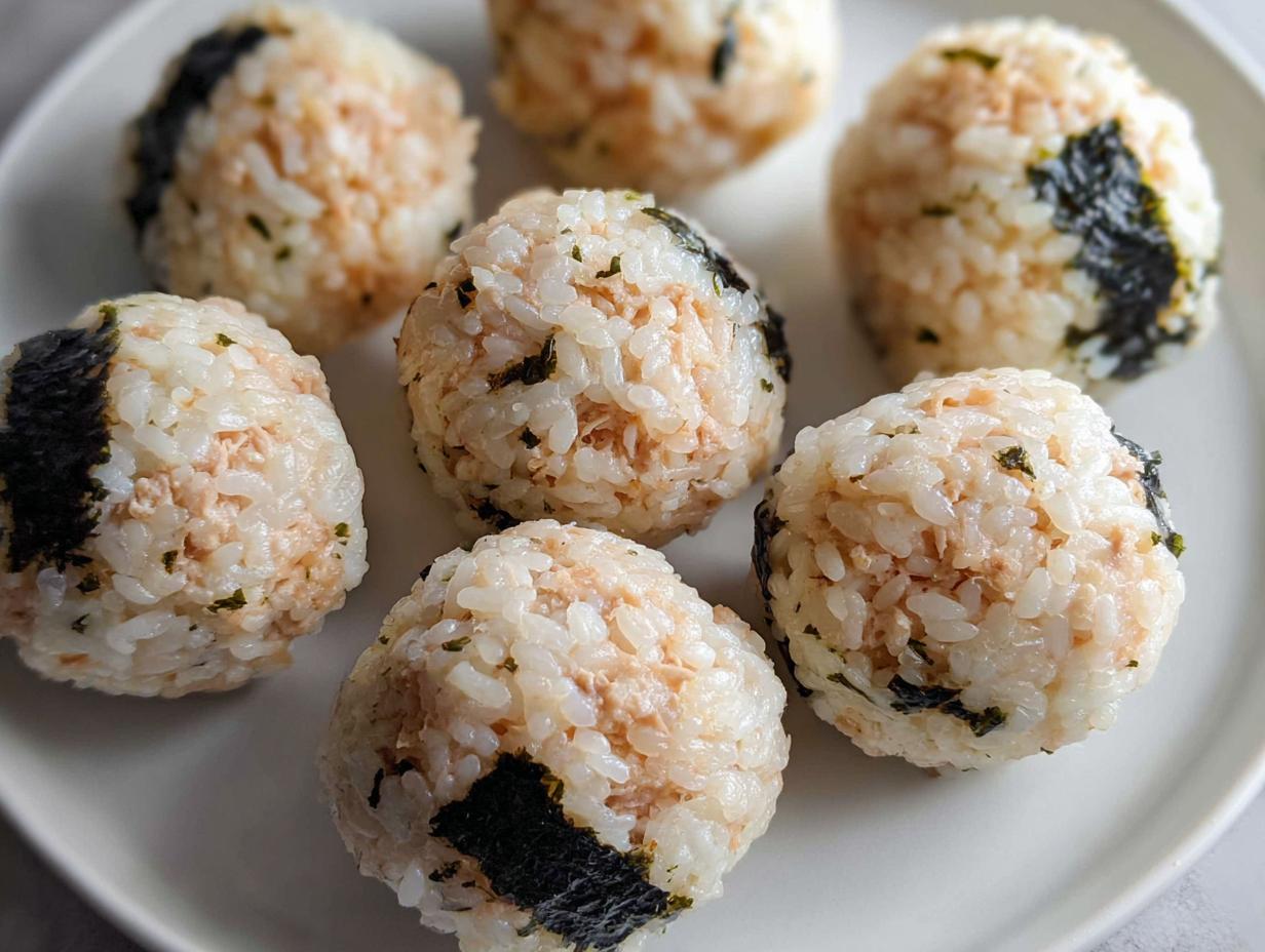 Close-up of several finished Tuna Sushi Ball Recipe portions arranged on a white plate.