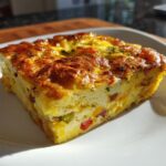 A square slice of golden-brown Breakfast Bake Perfect for Lunchboxes on a white plate.