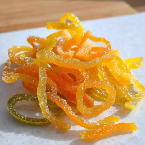 Close-up of candied orange and lemon strips, glistening with sugar, representing Classic Mixed Peel.