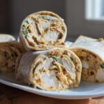 Close-up of sliced Honey Mustard Chicken Pinwheels showing chicken breast, sauce, and spinach rolled in a tortilla.