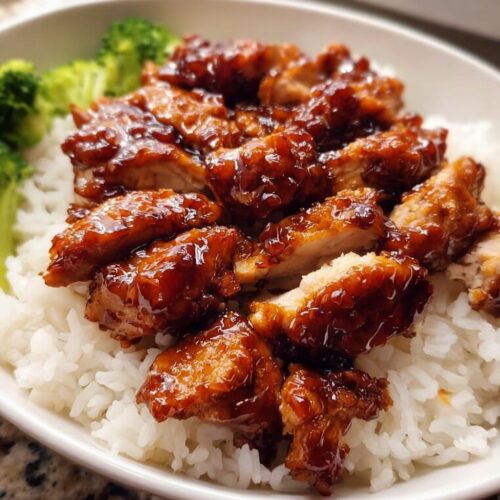 Close-up of glossy, saucy Kid-Friendly Teriyaki Chicken pieces served over fluffy white rice with steamed broccoli.