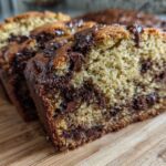 Close-up of three slices of moist One-Bowl Chocolate Chip Banana Bread on a wooden board.