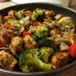 Close-up of seasoned chicken pieces with broccoli, mushrooms, and red peppers in a skillet, perfect for a One-Dish Chicken Keto Dinner.