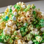 Close-up of White Chocolate Leprechaun Popcorn mixed with green coating and colorful mini marshmallows.