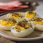 Five halves of deviled Boiled Eggs with Everything Bagel Seasoning sprinkled generously on the creamy yolk filling.