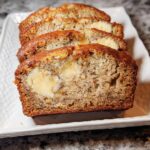 Close-up of sliced Buttery Sour Cream Banana Bread showing a moist crumb and a visible cream cheese filling swirl.