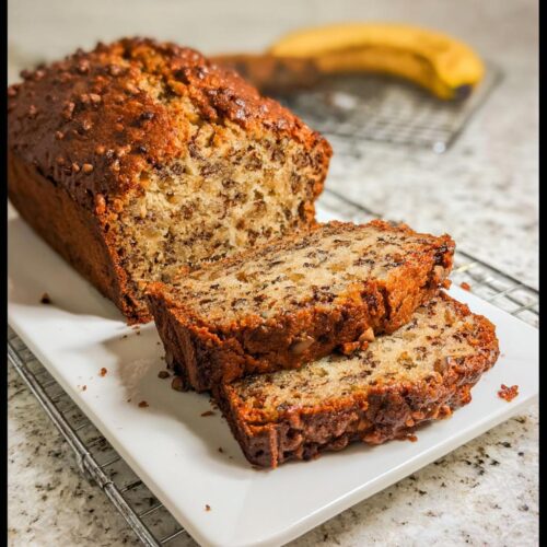 Two slices of Easy Cinnamon Banana Quick Bread cut from a loaf, showing moist texture and nuts.