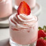 A serving of Easy Whipped Strawberry Mousse topped with whipped cream and a fresh strawberry slice.