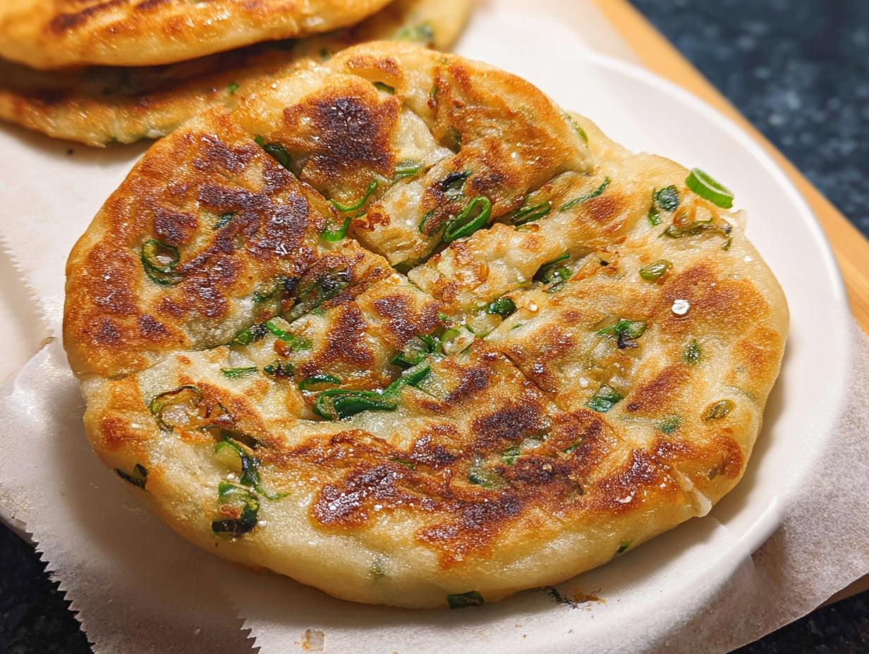 Close-up of a golden-brown, pan-fried Frozen-to-Pan Scallion Pancake with visible green scallions.