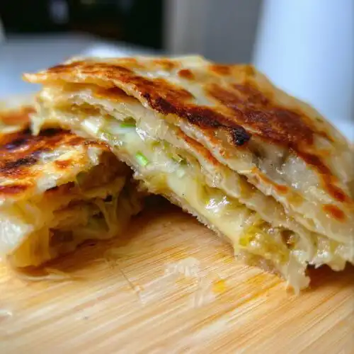 Close-up of a halved Scallion Pancakes Stuffed with Cheese showing melted cheese and scallions inside.