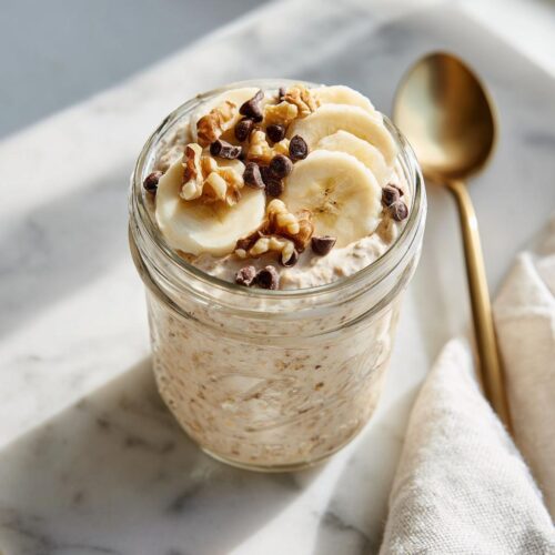 Close-up of Blended Banana Bread Overnight Oats topped with banana slices, walnuts, and mini chocolate chips.