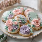 A plate of beautifully decorated sugar cookies featuring piped buttercream flowers, perfect for Floral Baby Shower Decorated Cookies.