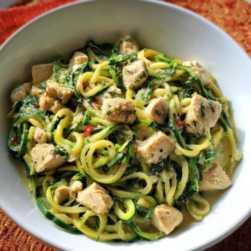 Close-up of Healthy Garlic Parmesan Chicken Pasta featuring zucchini noodles and cubed chicken in a creamy sauce.