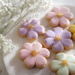 Pastel-colored, flower-shaped Wildflower Baby Shower Cookies decorated with gold sprinkles.