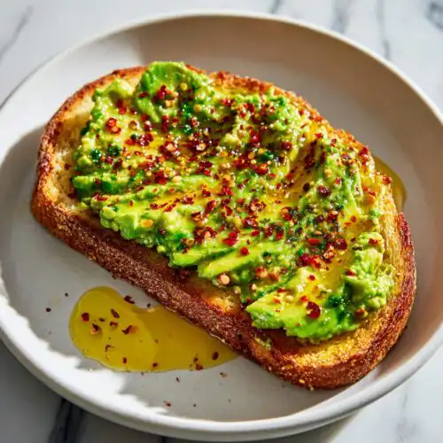 Close-up of vibrant avocado toast with chili flakes and olive oil, embodying a great Breakfast Toast Aesthetic.