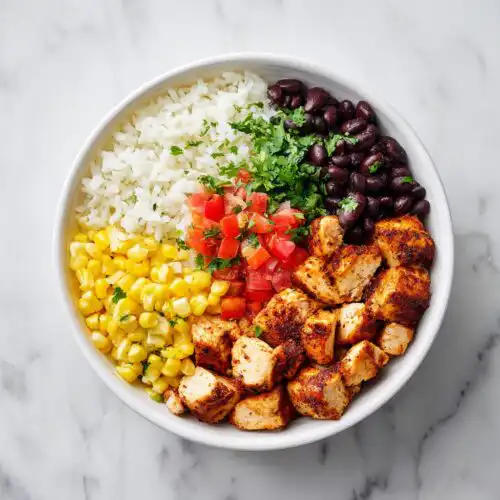 Overhead view of a Chicken Burrito Bowl Meal Prep serving with seasoned chicken, rice, corn, black beans, and pico de gallo.